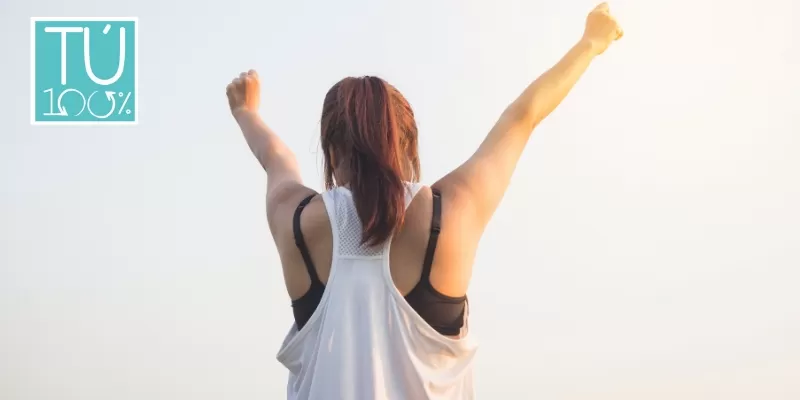 Mujer brazos levantados celebrando una conquista